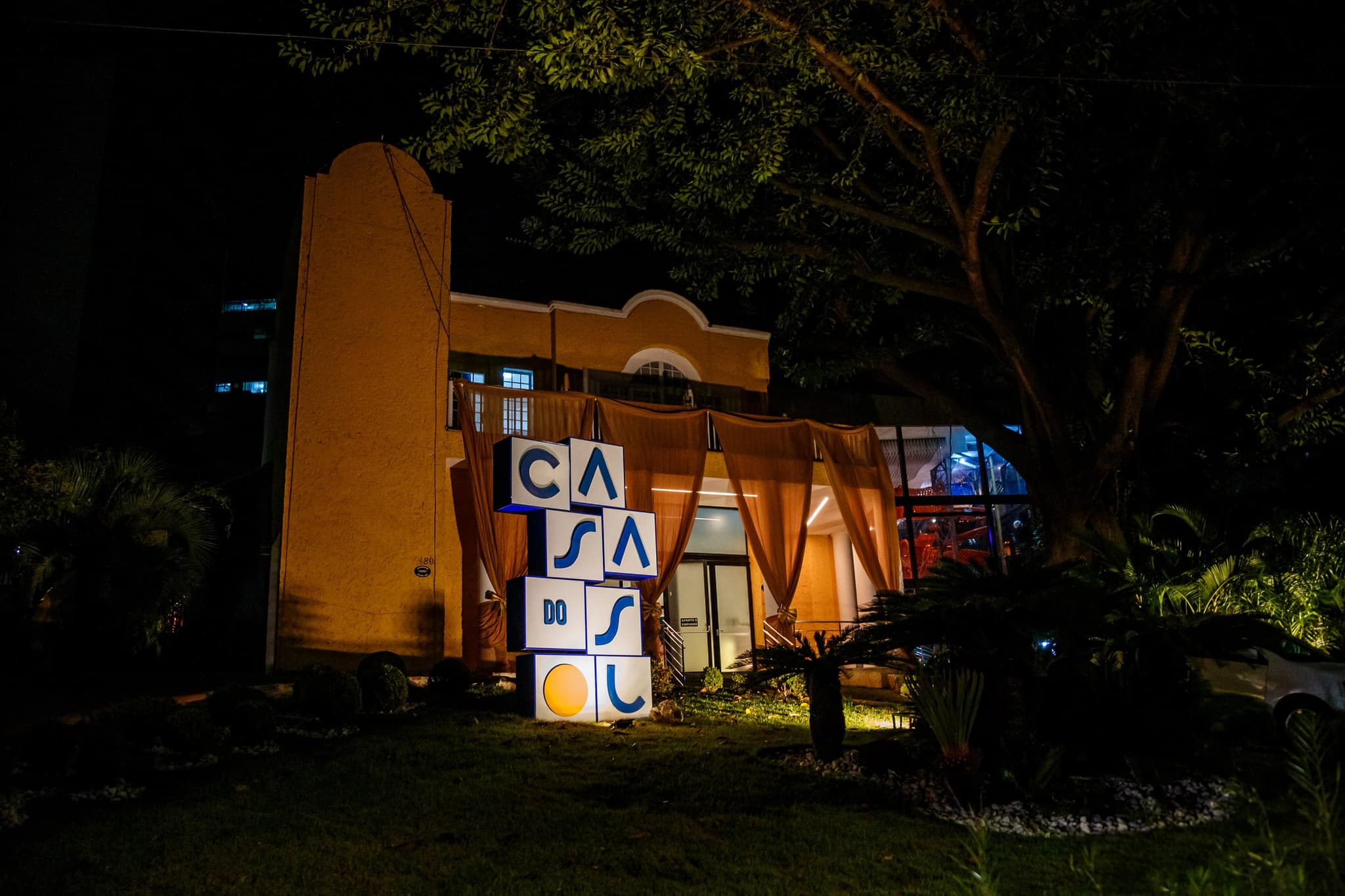 Fachada iluminada da Casa do Sol Cidade Nova à noite