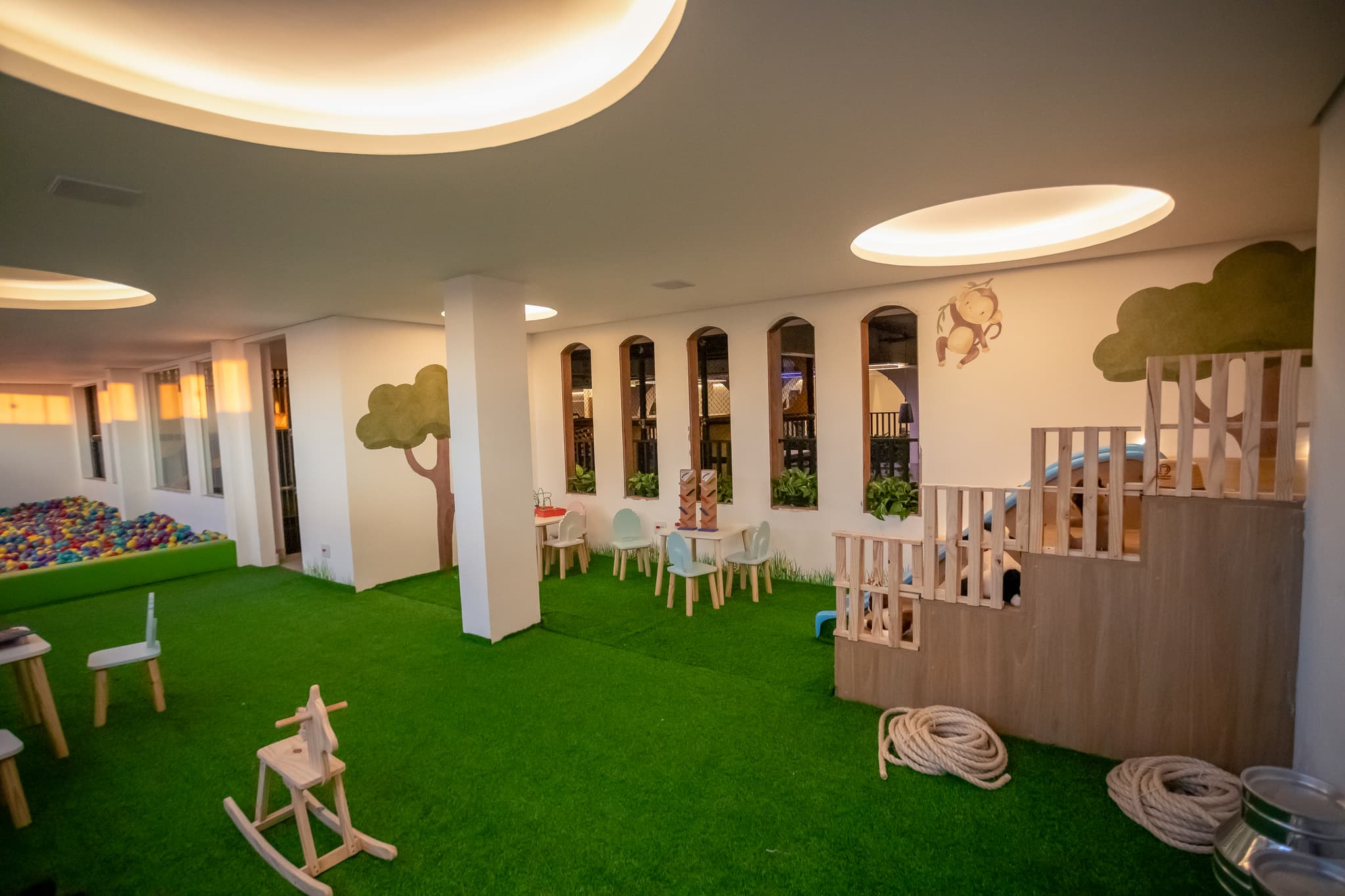 Área baby da Casa do Sol Estúdios com brinquedos, grama sintética e iluminação suave