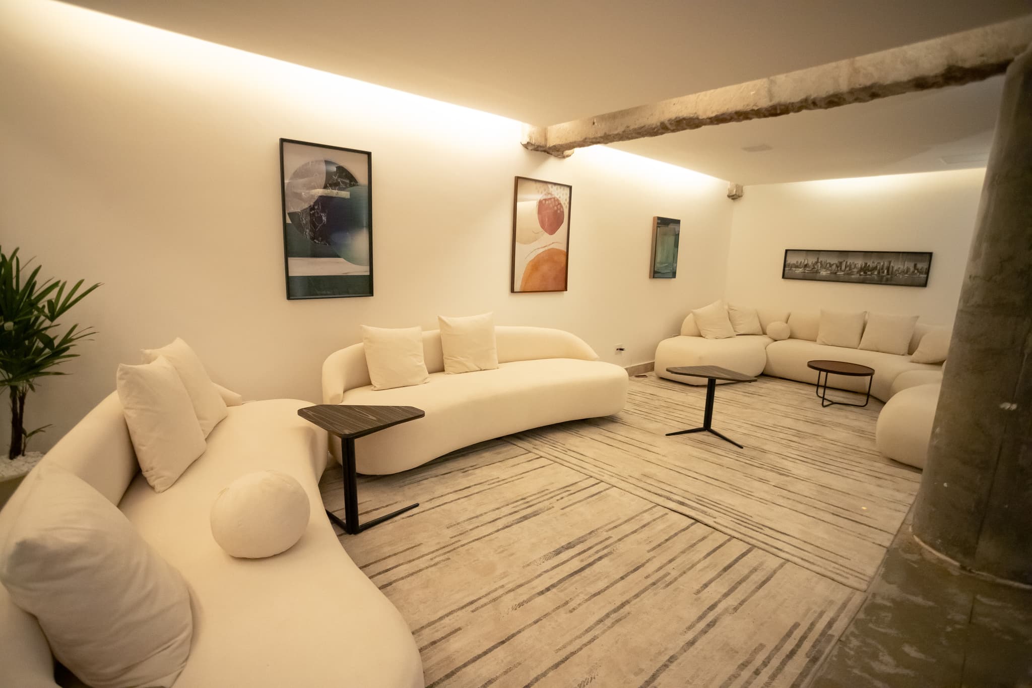 Lounge branco da Casa do Sol Estúdios com sofás curvos e atmosfera autoral