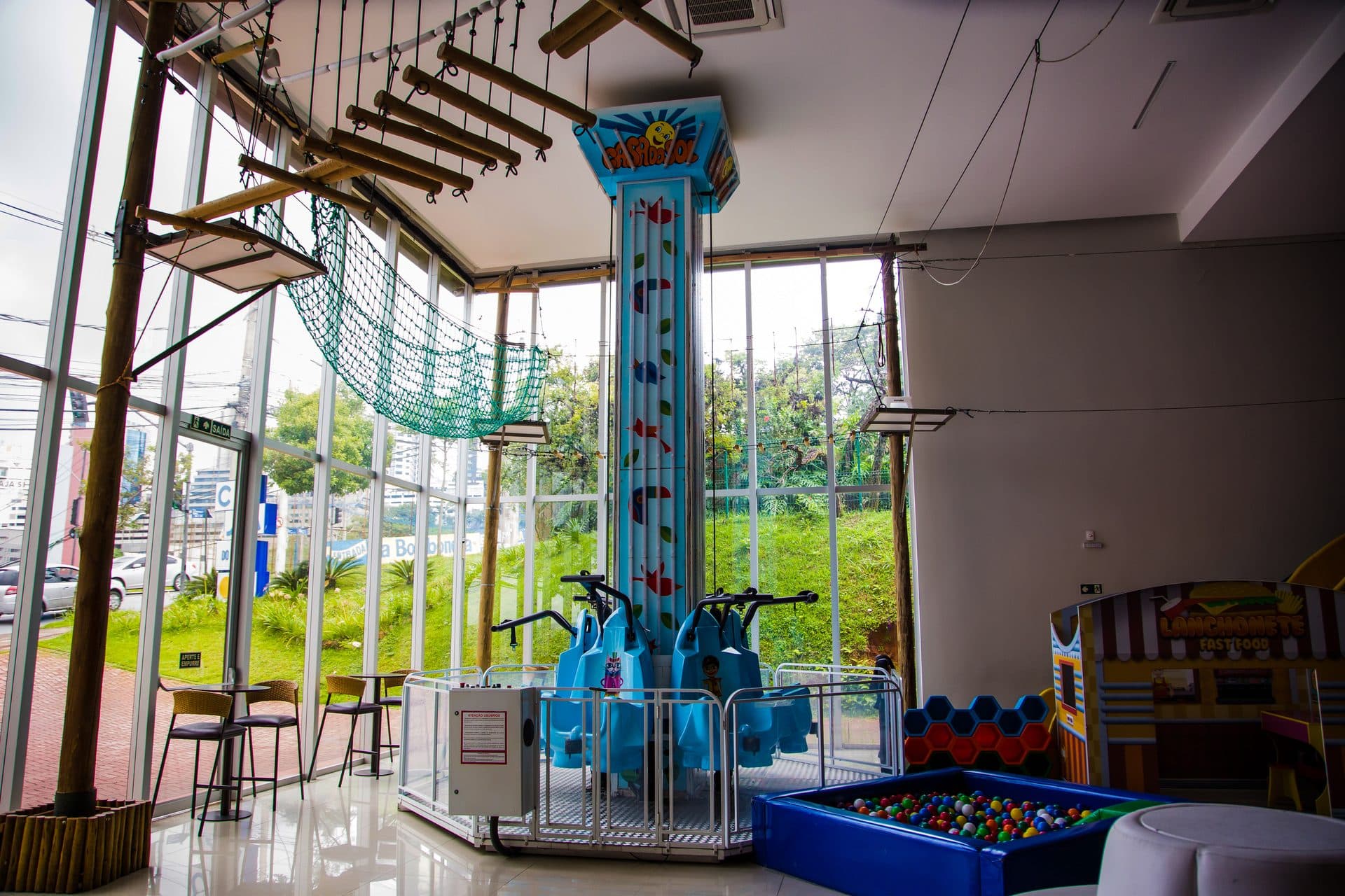 Área interna da Casa do Sol Jardim com vidro, pé-direito e brinquedo vertical