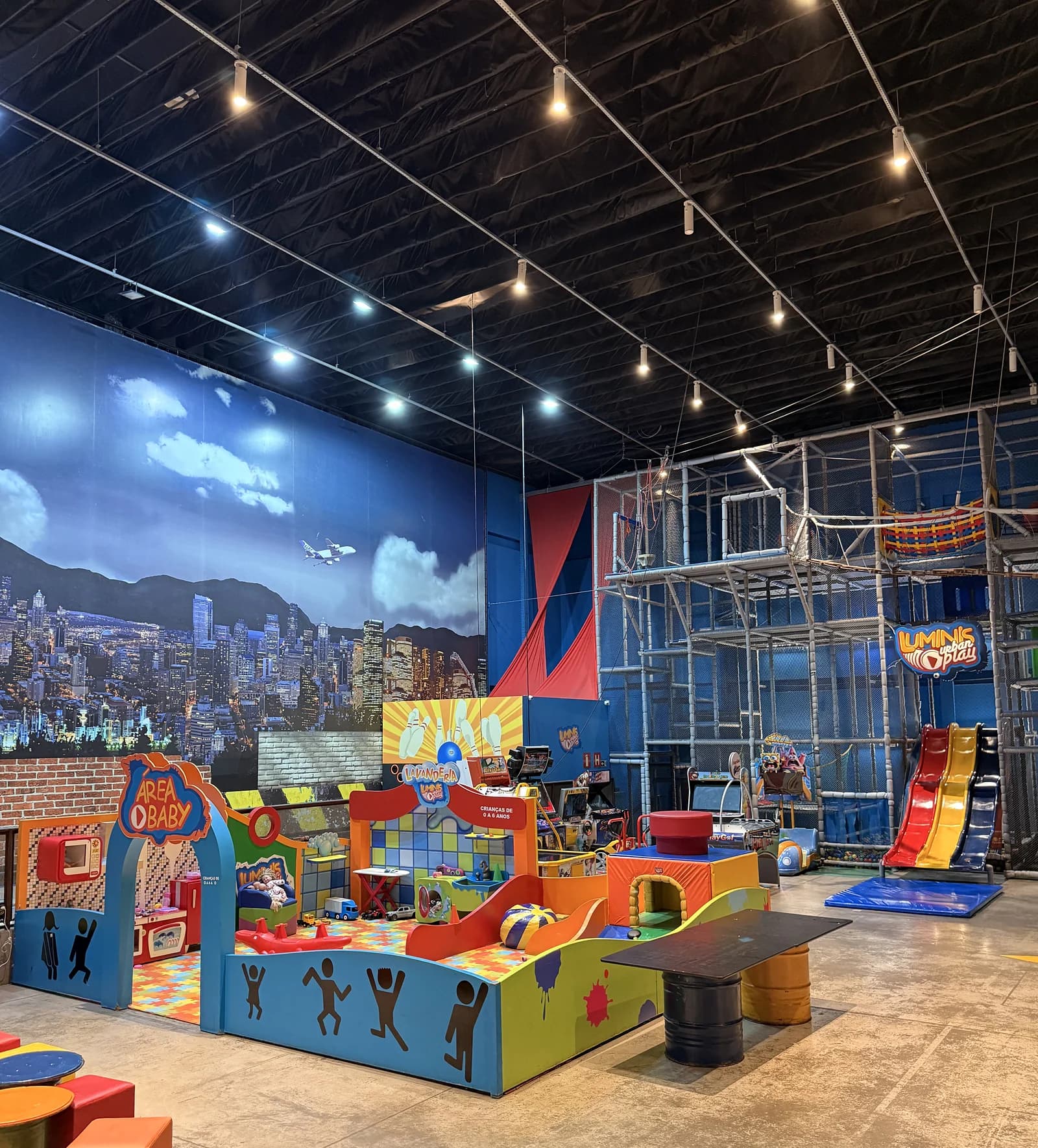Parque do Luminis com mural da cidade, área baby, kid play e escorregador colorido no mesmo salão.